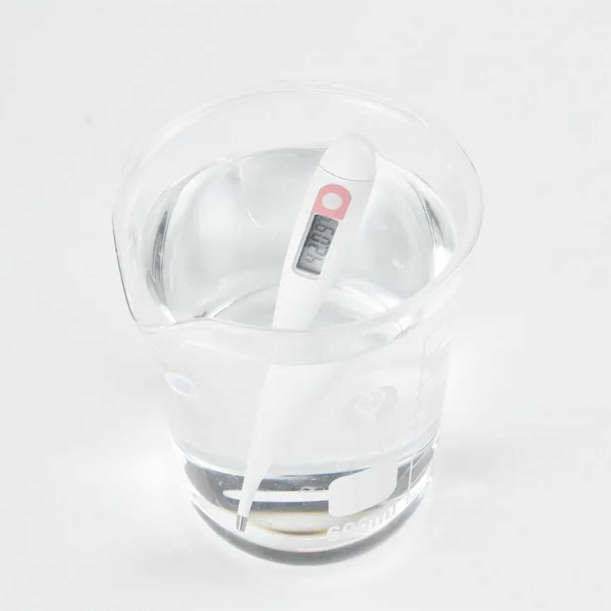 Thermometer in glass of water displaying waterprood digital bbt for tracking ovulation date